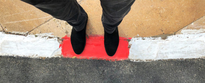man standing on sidewalk red