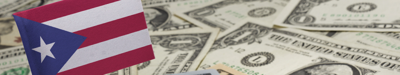 Flag of Puerto Rico sticking in a variety of american banknotes