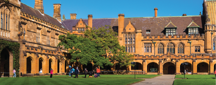 Sydney Uni inner yard with students in the distance enjoying break. University of Sydney courtyard against deep blue sky with white clouds, daytime photo